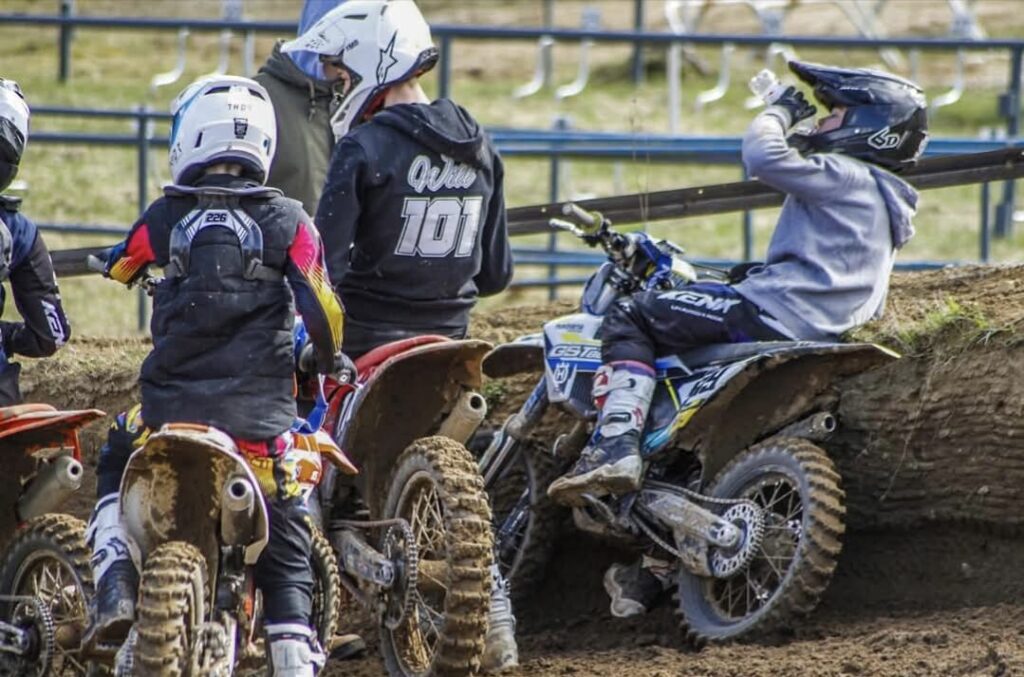 Junge Motocross-Fahrer machen Pause am Streckenrand am Echoberg in Tessin